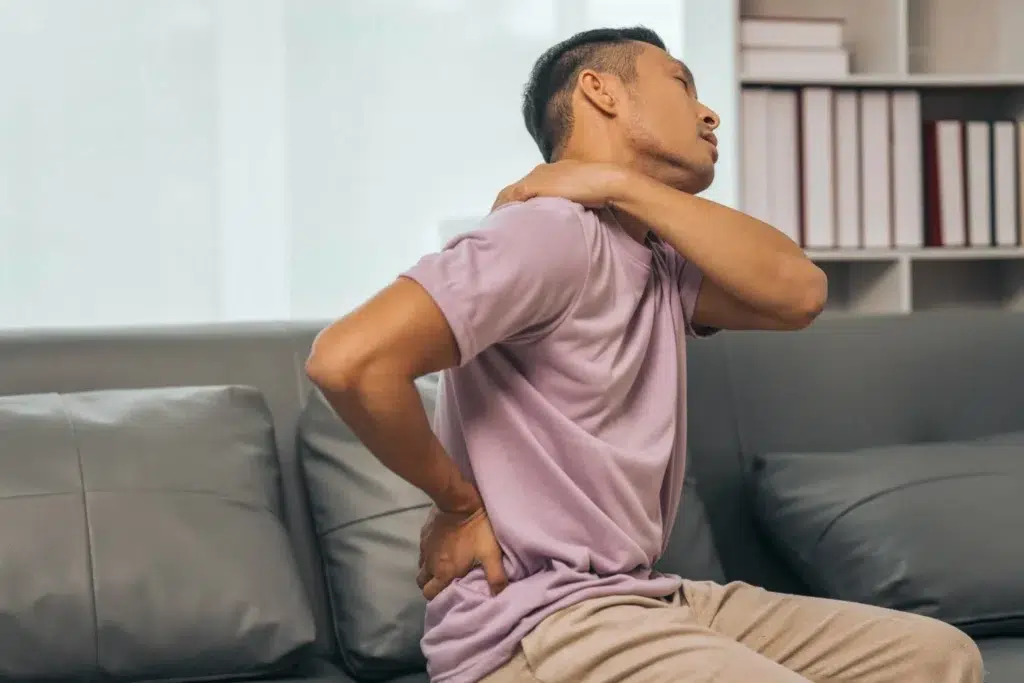 Man at his home holding lower back due to possible spinal stenosis in Palm Beach Gardens, FL Man at his home holding lower back due to possible spinal stenosis in Palm Beach Gardens, FL