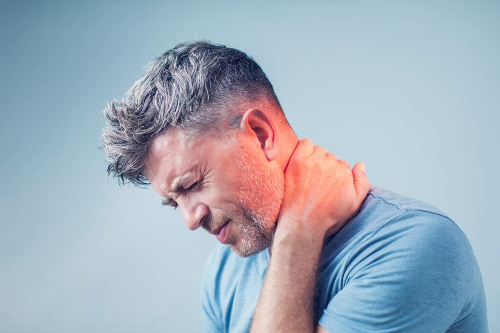Man holding his neck due to cervical disc pain. Man holding his neck due to cervical disc pain.